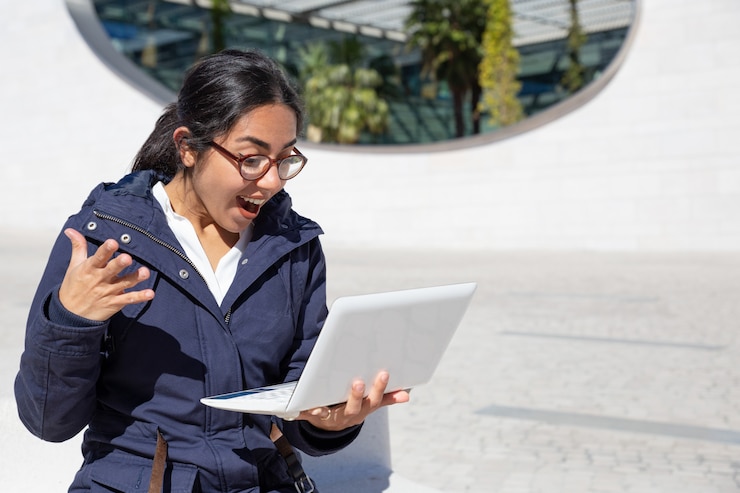 retrato mujer joven emocionada usando laptop al aire libre 1262 191811